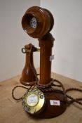 A vintage style turned wood pedestal/candlestick telephone with rotary dial, and twisted/braided