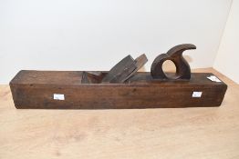 A large vintage wooden block plane, of traditional form 57cm