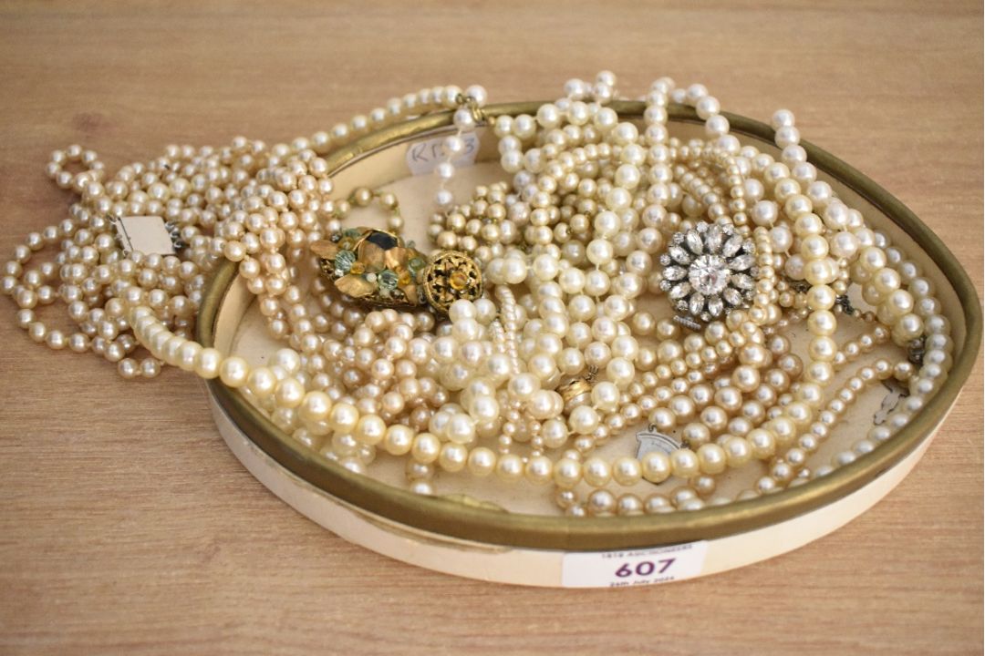 An assortment of faux pearl necklaces, of cream and white colour, some with paste set clasps