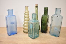 A selection of late 19th to early 20th-century coloured glass bottles, to feature blue, amber, green