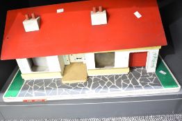 A mid-20th century dolls house in the form of a bungalow, possibly by Tri-ang. The model is of