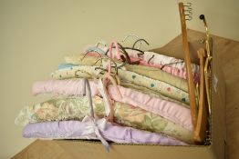 Assorted vintage coat hangers to include mostly satin covered along with some innovative metal