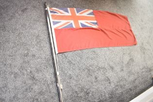 A British Red Ensign flag as used by British merchant ships 52cm x 117cm still attached to a partial