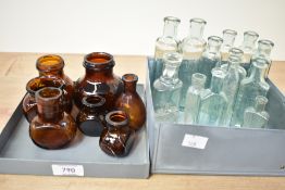 A collection of small vintage glass apothecary bottles in clear and green tint glass and a selection