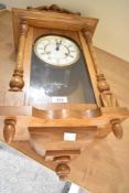 A 20th-century German oak Hermle wall regulator clock, featuring an ornate graduated pediment upon