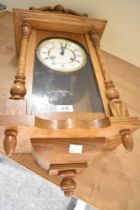 A 20th-century German oak Hermle wall regulator clock, featuring an ornate graduated pediment upon