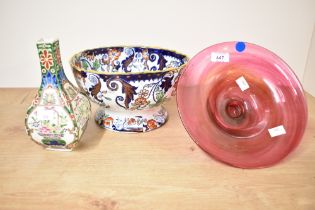 A 20th-century cranberry art glass pedestal bowl; sold with a small Oriental-style vase, featuring