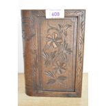 A vintage carved wood cigarette dispenser box, in the shape of a book, featuring floral detailing,