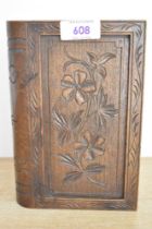 A vintage carved wood cigarette dispenser box, in the shape of a book, featuring floral detailing,