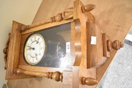 A 20th-century German oak Hermle wall regulator clock, featuring an ornate graduated pediment upon