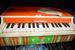 A vintage toy tabletop piano manufactured by Bontempi, presented in its original illustrated