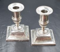 A pair of Victorian silver candlesticks, of traditional form having circular sconces with bead