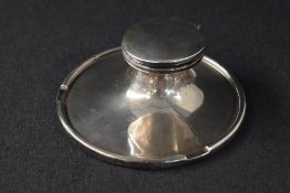 A George V silver inkwell, of circular form having 'K.T.' engraved to the inkwell lid, over a