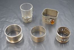 Two silver napkin rings, along with a Victorian silver mounted liqueur glass, a white metal napkin