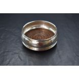 An Elizabeth II silver wine coaster, having a moulded rim with a wooden base, marks for London 1990,
