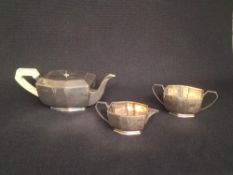 A George VI silver three piece tea set, comprising tea, sugar and cream, of angular rectangular form