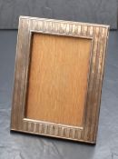 A late Edwardian silver mounted wooden photograph frame, having engine turned decoration with