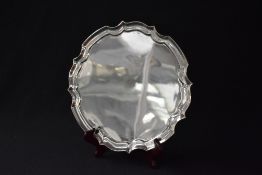 A George V silver salver, having a Chippendale style rim raised on four scroll feet, marks for