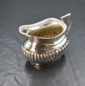 An Edwardian silver cream jug, of oval form having a gadrooned rim with a generous spout opposed