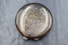 A silver makeup mirror compact, of circular form having a repousse map of India with rubies