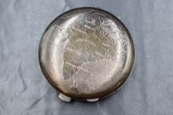 A silver makeup mirror compact, of circular form having a repousse map of India with rubies