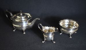 An Edwardian silver three piece tea set, comprising tea, sugar and cream, having Chippendale style