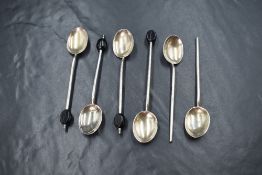 A cased set of six George V silver coffee bean spoons, having black 'beans' to terminals, two