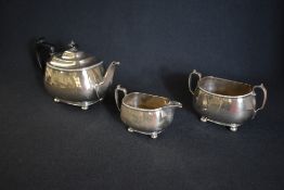 A George V silver harlequin tea set, comprising tea pot, sugar and cream, having an egg and dart