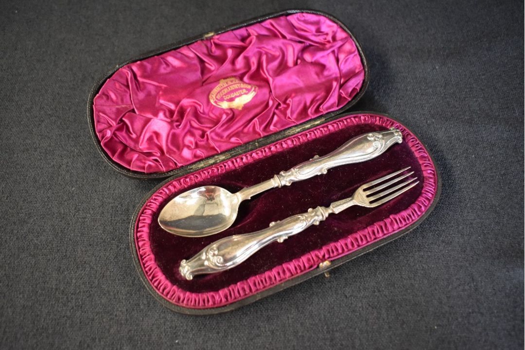 A cased Victorian silver christening set, comprising a spoon and fork with ornate scroll work to the - Image 2 of 2