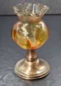 A Victorian silver mounted glass vase, the moulded amber glass raised on a silver circular step