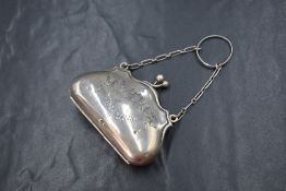 A George V silver coin purse, of traditional form having engraved floral and ribbon swags, with
