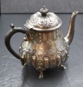 A Victorian silver teapot, of bulbous form having embossed foliate decoration, raised on four hoof