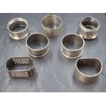 A group of seven silver napkin rings, having engine turned decoration, pierced scroll work and