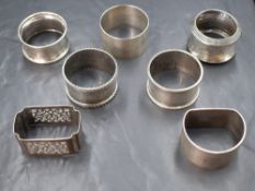 A group of seven silver napkin rings, having engine turned decoration, pierced scroll work and