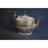 A Victorian silver teapot, of oval form having a half gadrooned body with angular handle, marks