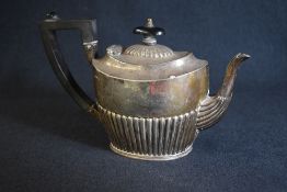A Victorian silver teapot, of oval form having a half gadrooned body with angular handle, marks