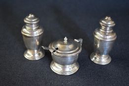 A cased George V three piece cruet set, comprising salt, mustard and pepper, of circular form raised
