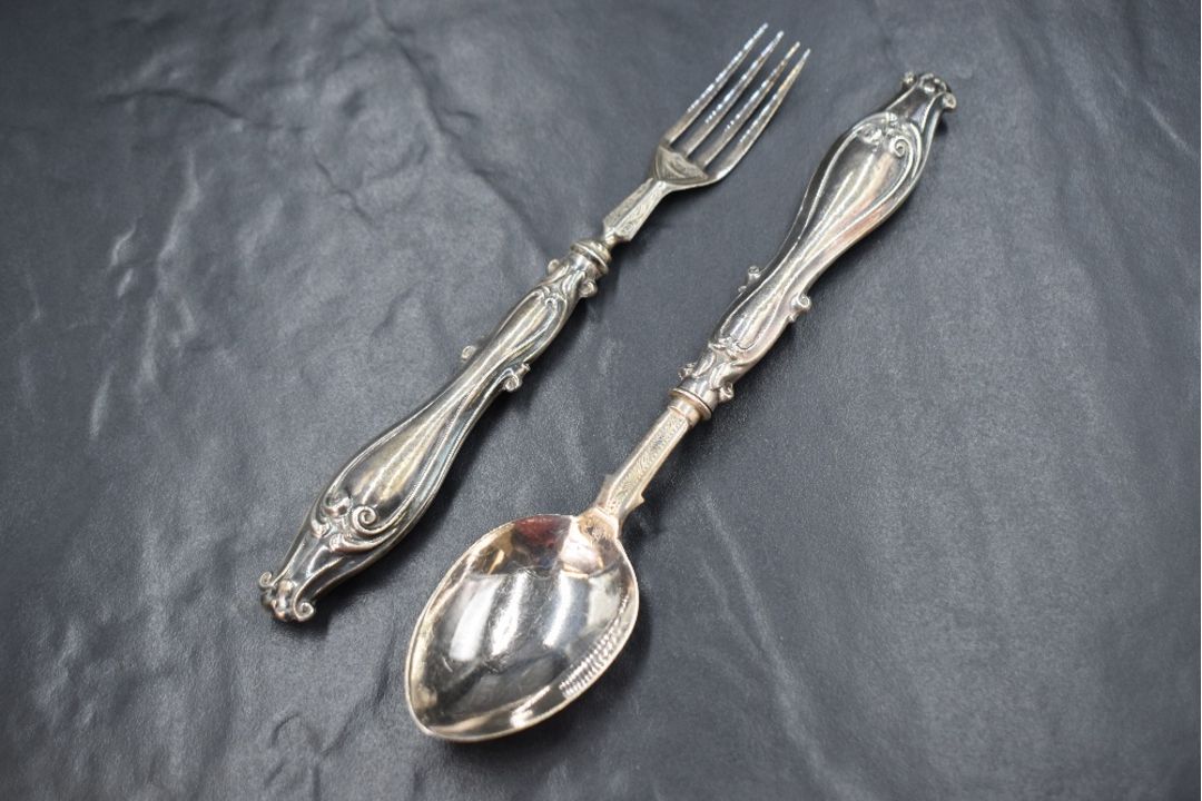 A cased Victorian silver christening set, comprising a spoon and fork with ornate scroll work to the - Image 1 of 2