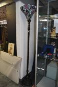 A tall 20th-century Tiffany-style floor lamp, featuring a fluted shade of pastel pink floral