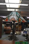 A contemporary Tiffany-style Tulip table lamp, featuring a soft orange shade with repeating tulip