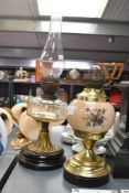 Two 20th-century brass Victorian-style oil lamps, to include a decorative bird reservoir example,