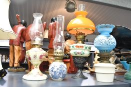 A quantity of late 19th to 20th-century ceramic and glass oil lamps, to feature a Hinks example