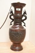 A Chinese cast and patinated metal dragon handled vase, later converted to a table lamp, cast in two