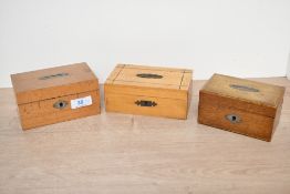 Three small 20th-century wooden coin boxes, having hinged lids and decorative escutcheons, some