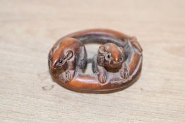 A small 20th-century Japanese boxwood netsuke, modelled as two mice upon a branch, two holes to