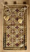 An antique tabletop woolwork hanging in greens, pale blues and burgundy, suggestive of Swedish