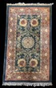 A vintage wool small area rug having an Art Nouveau style central symmetrical sunflower design,