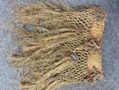 Three 20th century woven grass skirts, each showcasing varying knotting and weaving techniques.