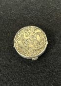 An antique French-made silver plated makeup compact having an abstract debossed animal and organic