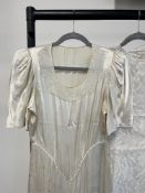 A 1930-40s wedding dress in heavy cream satin with puff sleeve, empire waist, pooling skirt and